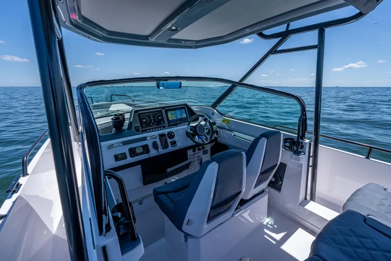 Slide: The Image of 2022 Axopar 28 T-Top Brabus boat interior with modern dashboard and ocean view. - 32