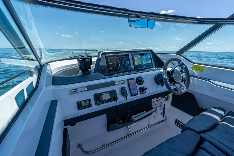Slide: The Image of 2022 Axopar 28 T-Top Brabus helm with modern navigation equipment on open water. - 35