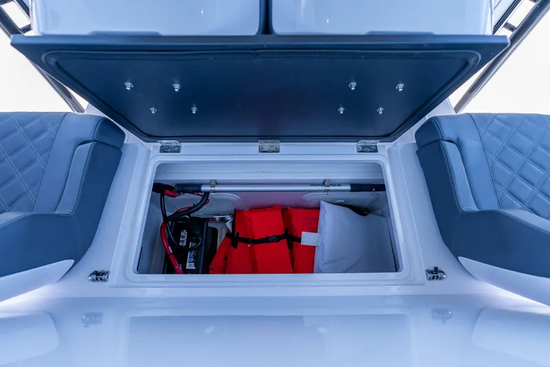 Slide: The Image of Open storage compartment in 2022 Axopar 28 T-Top Brabus, featuring life jackets and equipment. - 39