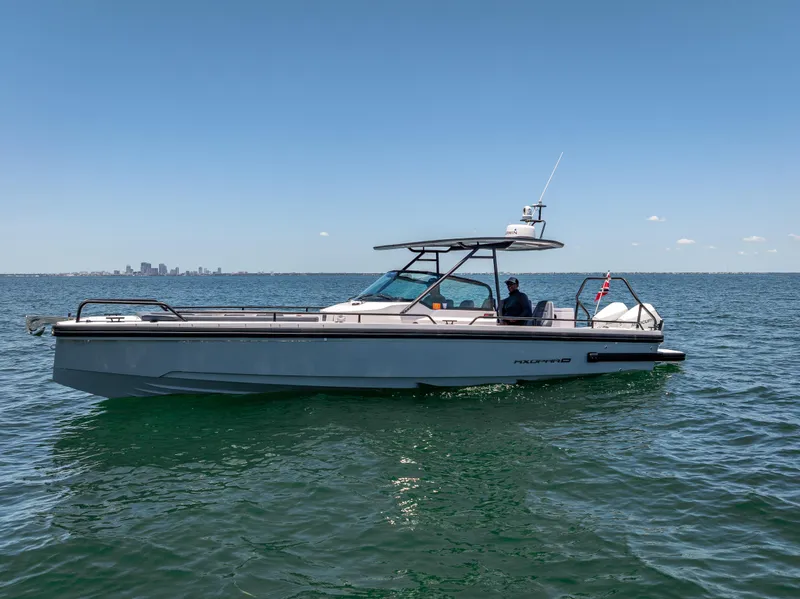 Slide: The Image of 2022 Axopar 28 T-Top Brabus boat cruising on open water under clear blue sky. - 5
