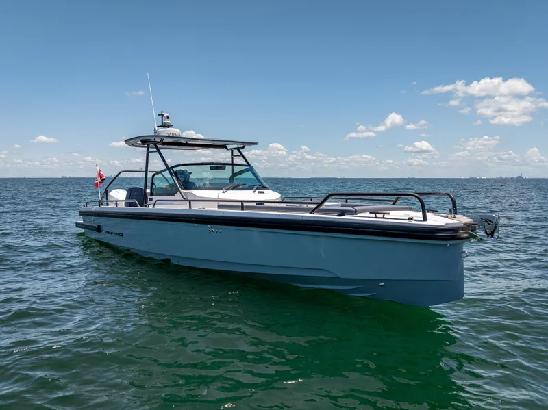 Slide: The Image of 2022 Axopar 28 T-Top Brabus boat on open water under clear sky. - 7