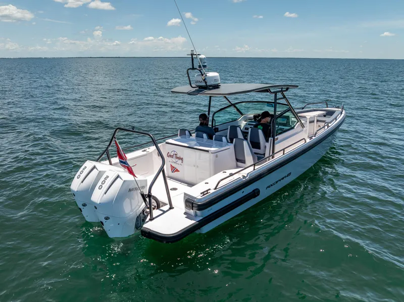 Slide: The Image of 2022 Axopar 28 T-Top Brabus boat cruising on open water, featuring dual Mercury engines. - 9