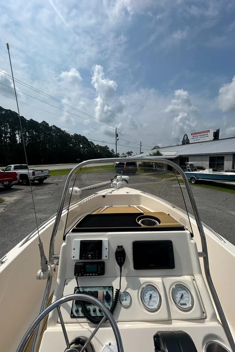 Slide: The Image of 2006 Key West 176 CC Sportsman boat dashboard with gauges and steering wheel under a cloudy sky. - 3