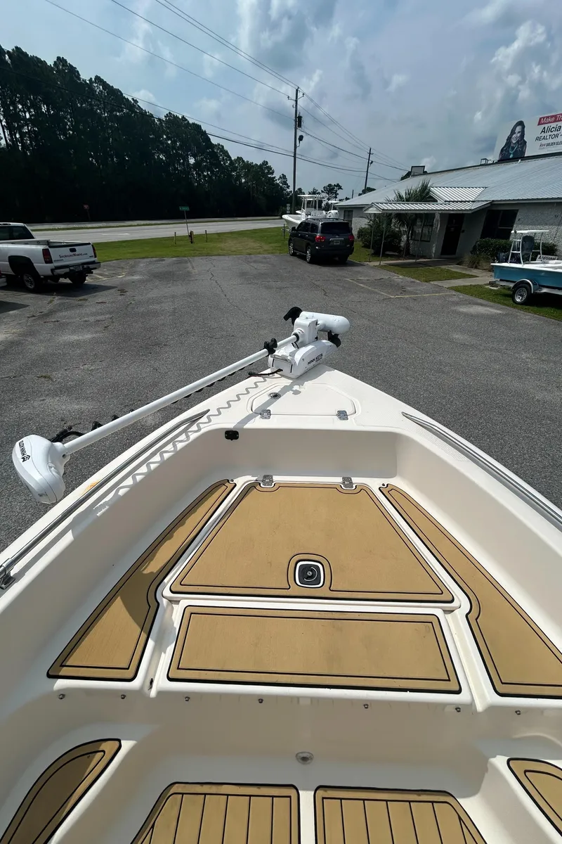 Slide: The Image of 2006 Key West 176 CC Sportsman boat with tan deck, parked outdoors. - 8