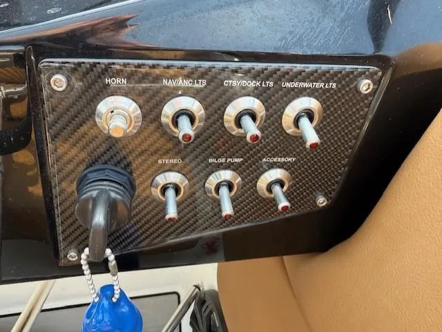 Slide: The Image of Control panel of 2021 Glastron GTD 240 boat with various switches and key. - 12