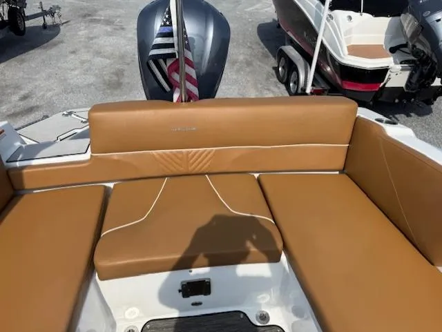 Slide: The Image of 2021 Glastron GTD 240 boat with tan seating and American flag in the background. - 18