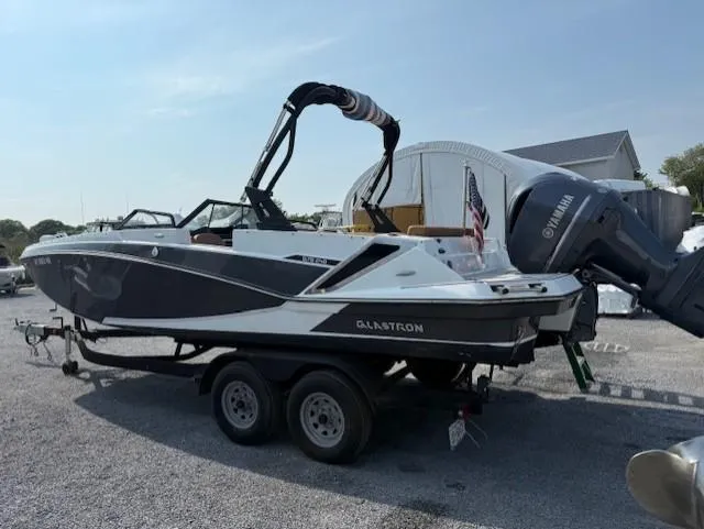 Slide: The Image of 2021 Glastron GTD 240 boat on trailer with Yamaha outboard motor, parked outdoors. - 3