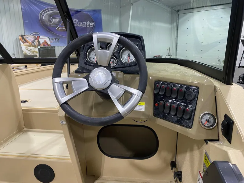 Slide: The Image of 2025 G3 Sportsman 2400 boat dashboard with steering wheel and control panel. - 6