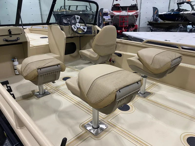 Slide: The Image of 2025 G3 Sportsman 2400 boat interior with beige seating and modern dashboard. - 8