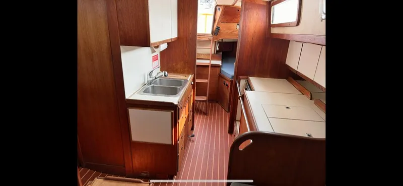 Slide: The Image of Interior of 1983 Sabre 38 sailboat with wooden cabinetry and compact kitchen area. - 12