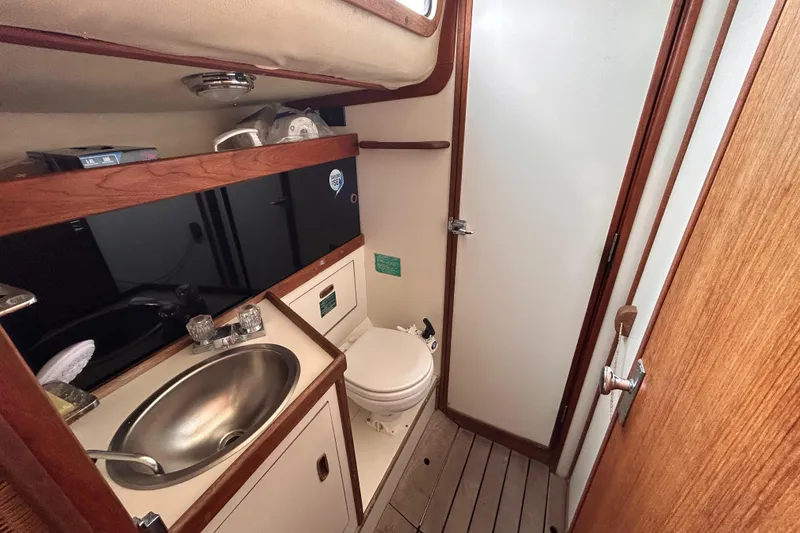 Slide: The Image of 1983 Sabre 38 yacht bathroom with sink, toilet, and wooden accents. - 14