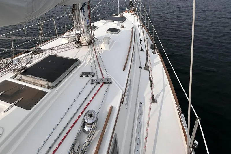 Slide: The Image of 1983 Sabre 38 sailboat deck with rigging and hatches, on calm water. - 29