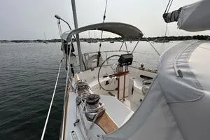 Slide: The Image of 1983 Sabre 38 sailboat cockpit with steering wheel, moored on calm water. - 30