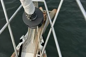 Slide: The Image of Bow of 1983 Sabre 38 sailboat with anchor and railing over water. - 32