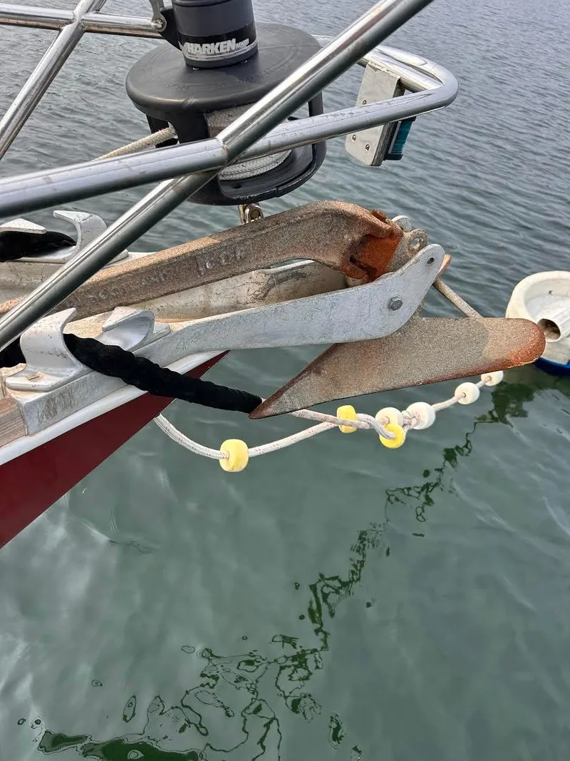 Slide: The Image of Anchor on a 1983 Sabre 38 sailboat, secured with a chain over calm water. - 33