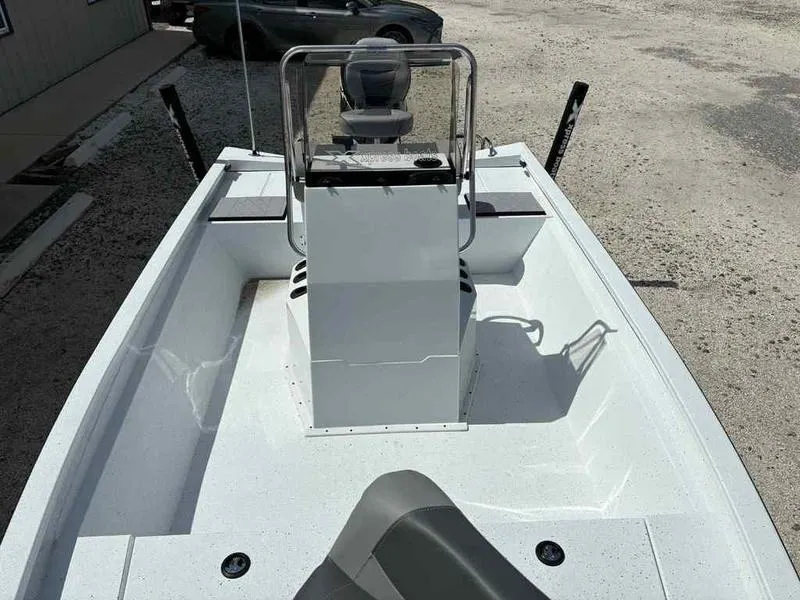 Slide: The Image of 2026 Xpress H190B boat interior with console and seating, parked on gravel. - 13