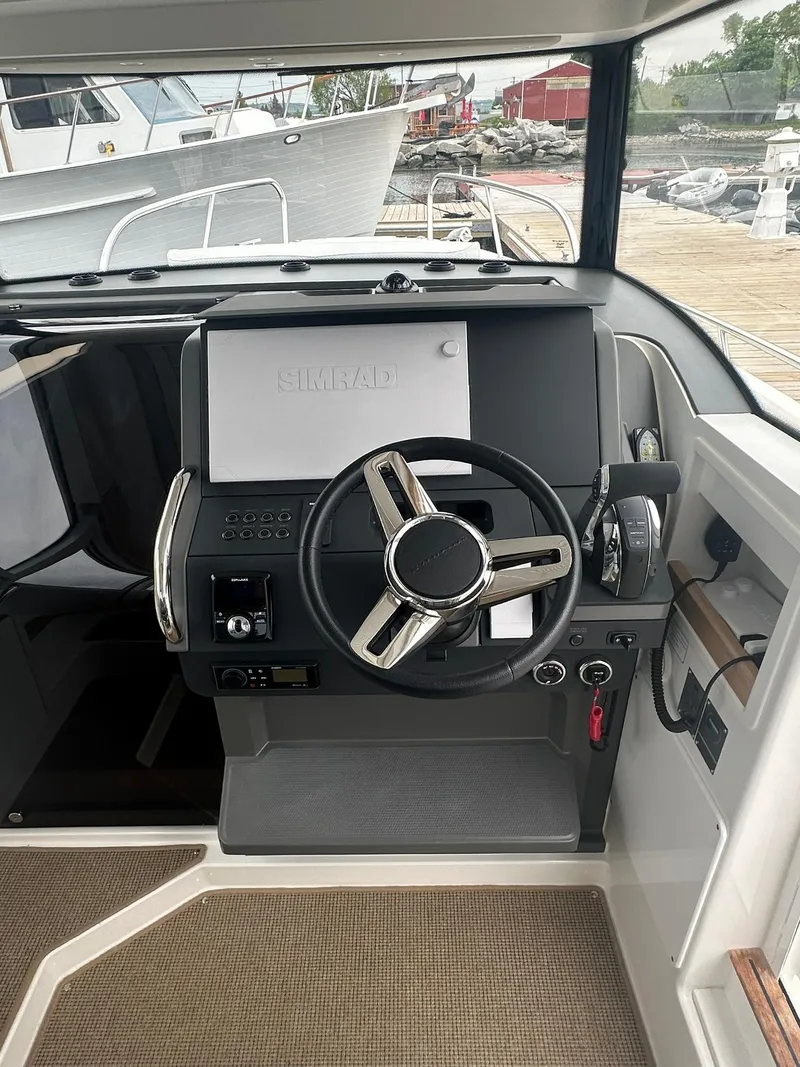 Slide: The Image of 2023 Nimbus Commuter 9 boat cockpit with steering wheel and control panel. - 11