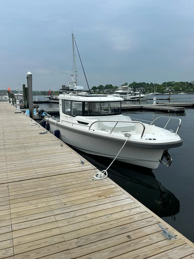 Slide: The Image of 2023 Nimbus Commuter 9 boat docked at a marina on a calm day. - 3
