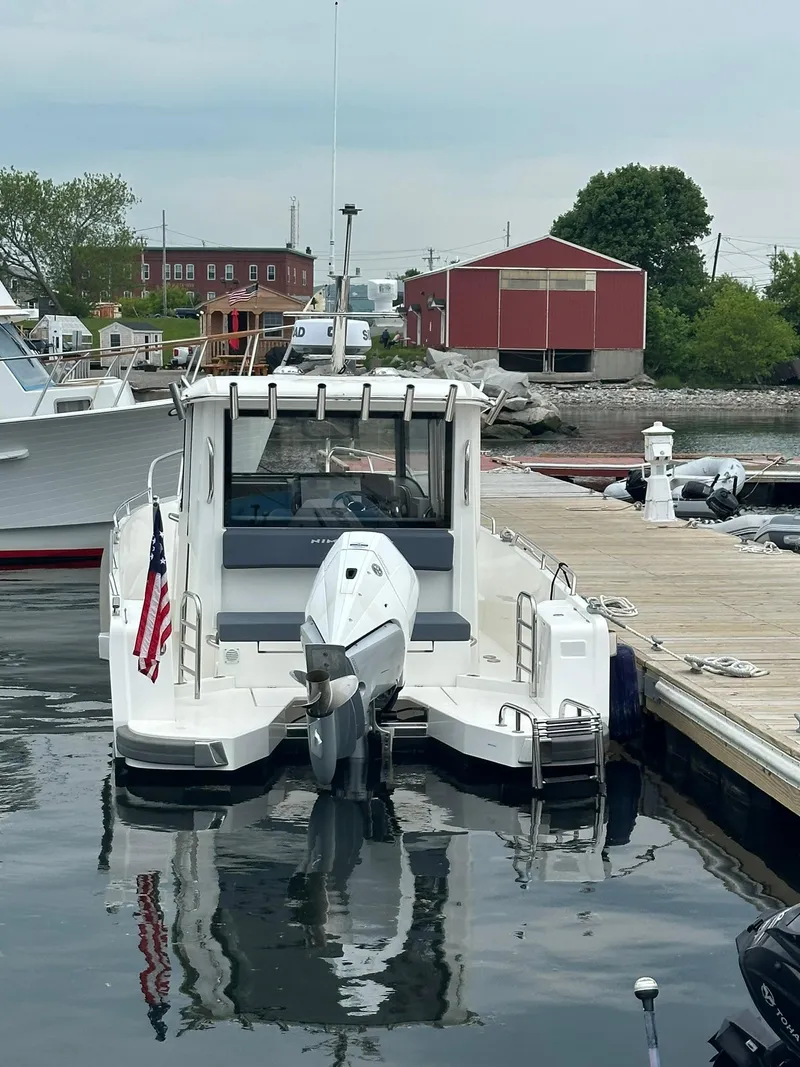 Slide: The Image of 2023 Nimbus Commuter 9 boat docked at marina with American flag. - 6
