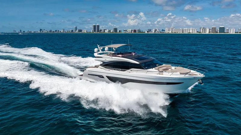 Slide: The Image of Luxury Princess S78 yacht cruising on open sea, city skyline in background, 2021 model. - 10