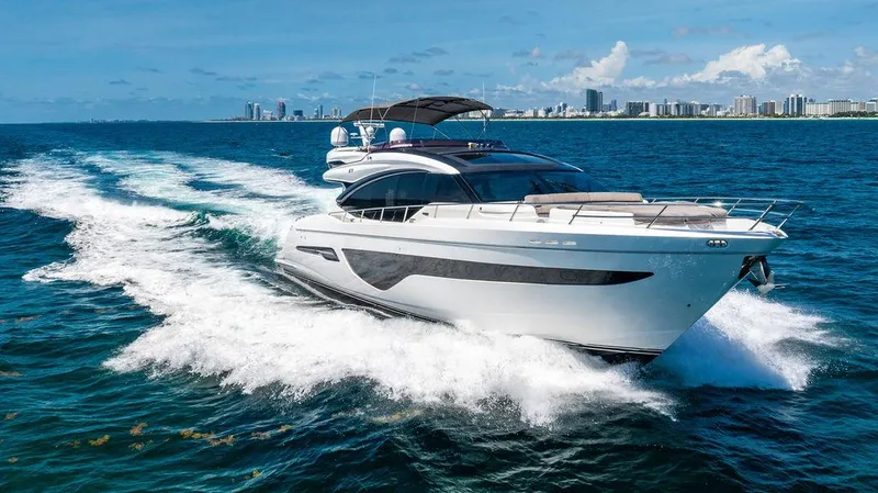 Slide: The Image of Luxurious 2021 Princess S78 yacht cruising on open sea with city skyline in background. - 2