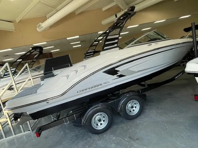The Image of 2025 Chaparral 23 SSi boat on trailer, blue and white design, parked outdoors. - 0