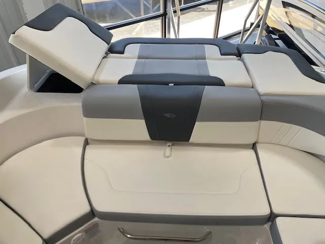 Slide: The Image of 2026 Chaparral 23 SSi boat interior with gray seating and speakers in a garage. - 6