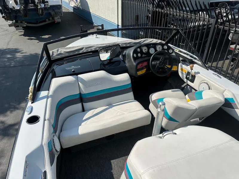 Slide: The Image of 1992 Correct Craft Ski Nautique boat interior with white and teal seating, dashboard, and steering wheel. - 11