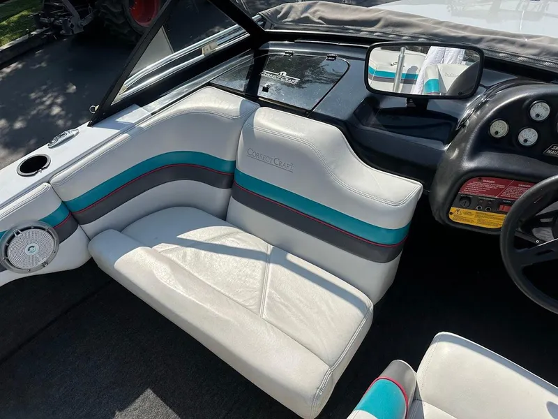 Slide: The Image of 1992 Correct Craft Ski Nautique interior with white and teal seating, dashboard, and steering wheel. - 17