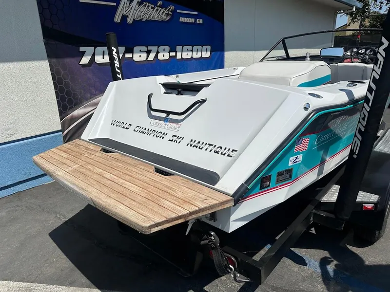 Slide: The Image of 1992 Correct Craft Ski Nautique boat with wooden swim platform, displayed outdoors. - 6