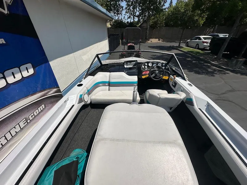 Slide: The Image of 1992 Correct Craft Ski Nautique boat interior with seating and dashboard, parked outdoors. - 9