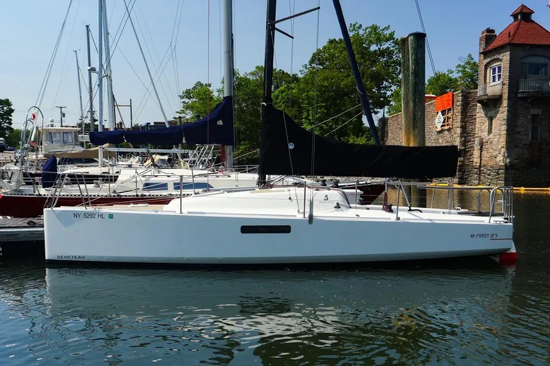 The Image of 2021 Beneteau First 27 SE sailboat docked in a marina, surrounded by other boats. - 0