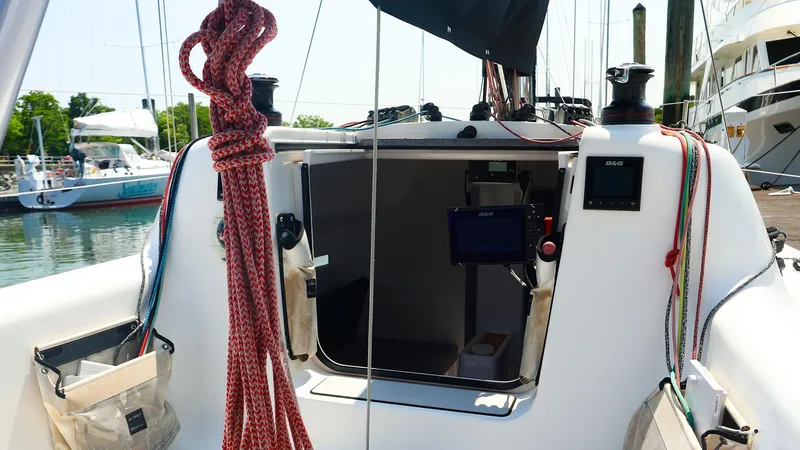 Slide: The Image of Cockpit view of 2021 Beneteau First 27 SE sailboat, featuring ropes and navigation equipment. - 13