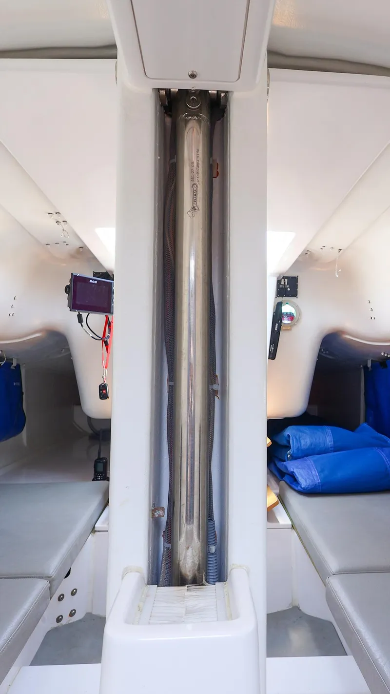 Slide: The Image of Interior view of 2021 Beneteau First 27 SE sailboat cabin with seating and storage. - 27