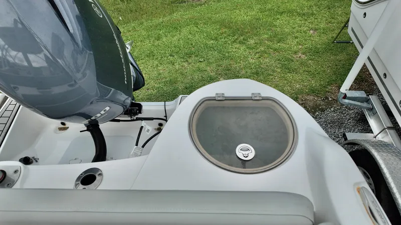 Slide: The Image of 2023 Sea Fox 226 Traveler boat with engine and storage compartment, parked on grass. - 12