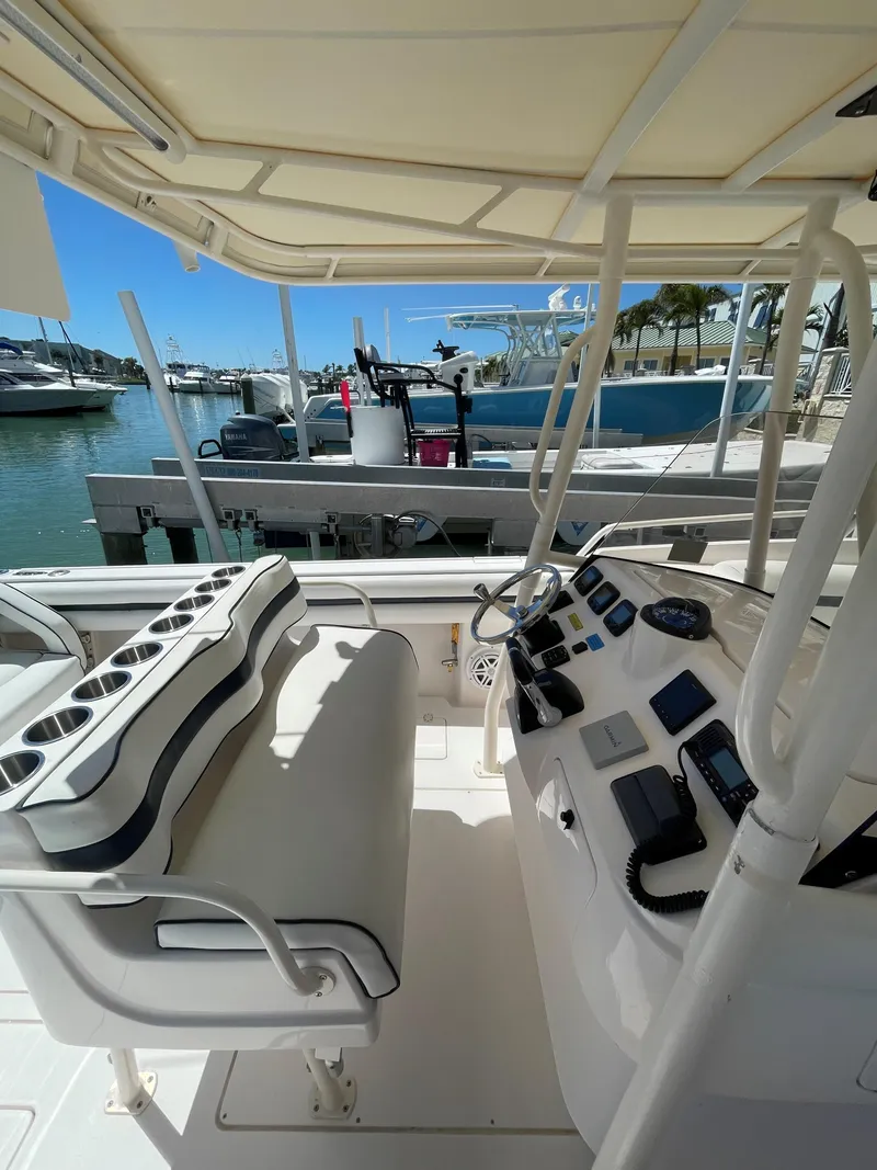 Slide: The Image of 2008 Intrepid 323 Cuddy boat interior with helm and seating at marina. - 2