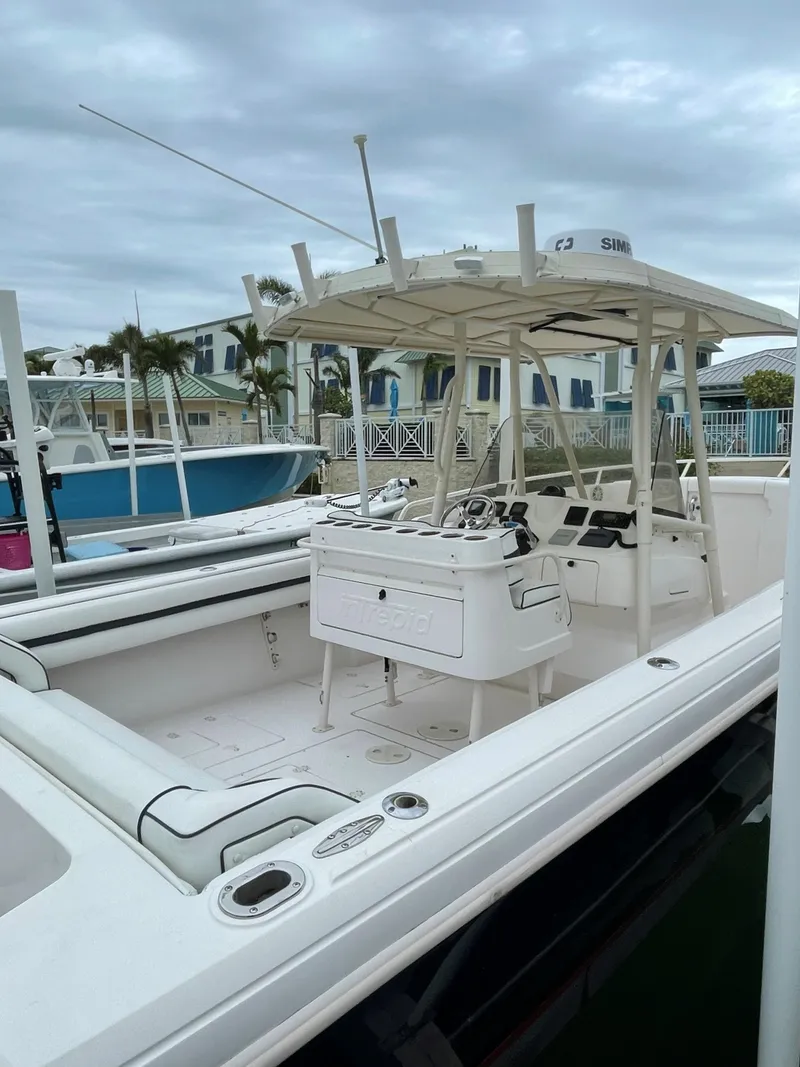 Slide: The Image of 2008 Intrepid 323 Cuddy boat docked, featuring spacious deck and modern design. - 5