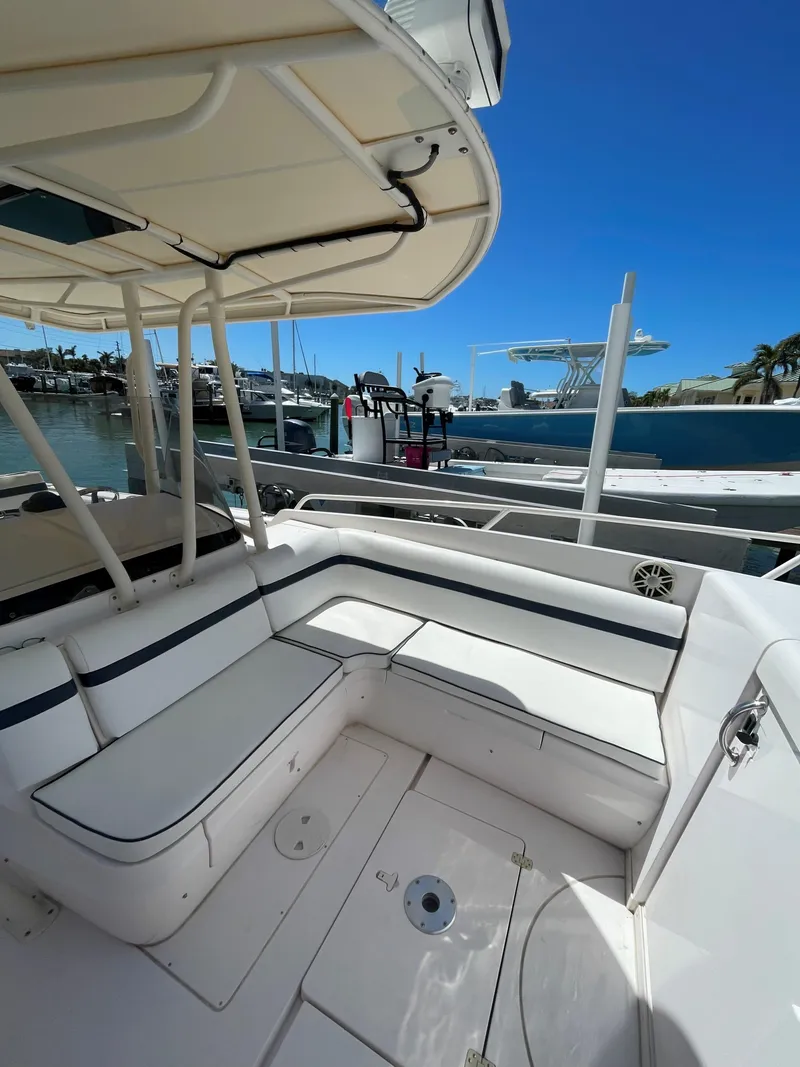 Slide: The Image of 2008 Intrepid 323 Cuddy boat with spacious seating, docked at a marina under clear blue skies. - 6