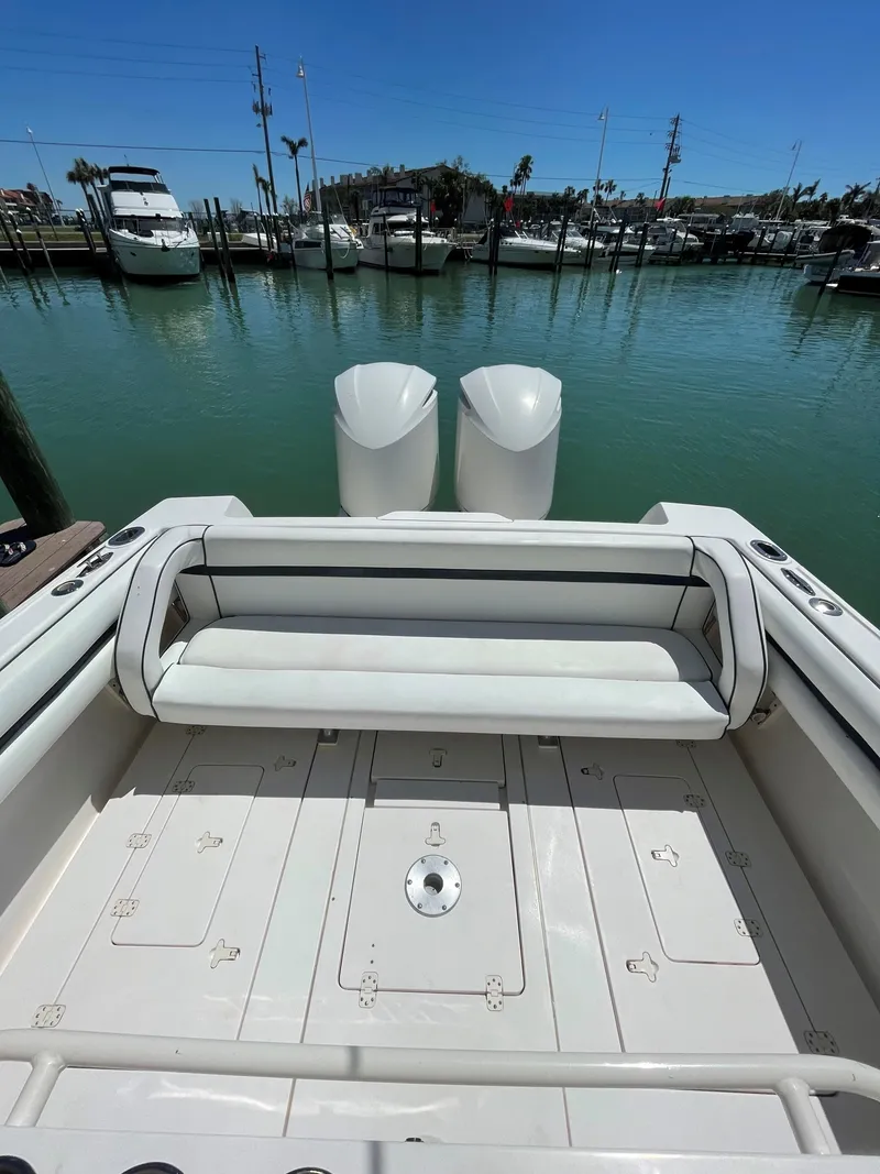 Slide: The Image of 2008 Intrepid 323 Cuddy boat with dual engines, docked in a marina. - 7