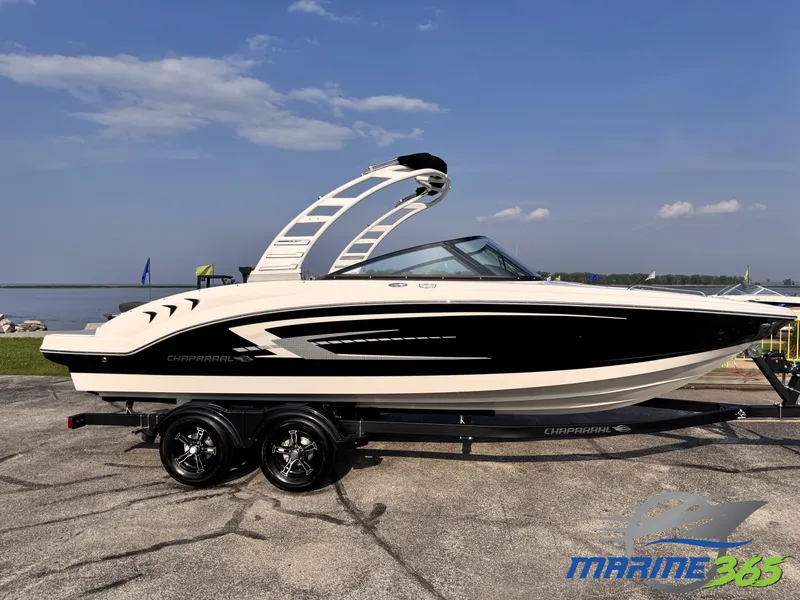 The Image of 2025 Chaparral 23 SSi boat on trailer by waterfront, clear sky background. - 0