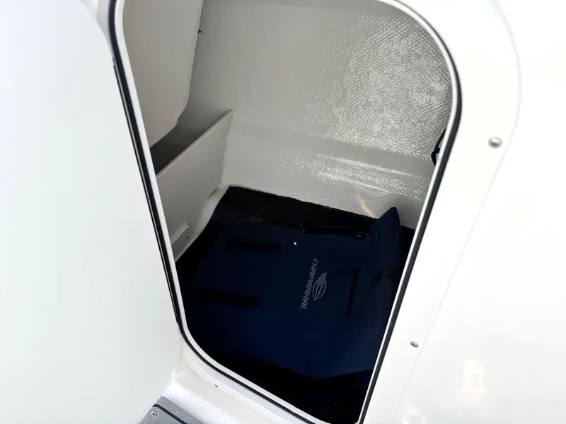 Slide: The Image of 2025 Chaparral 23 SSi storage compartment with a blue mat inside. - 23