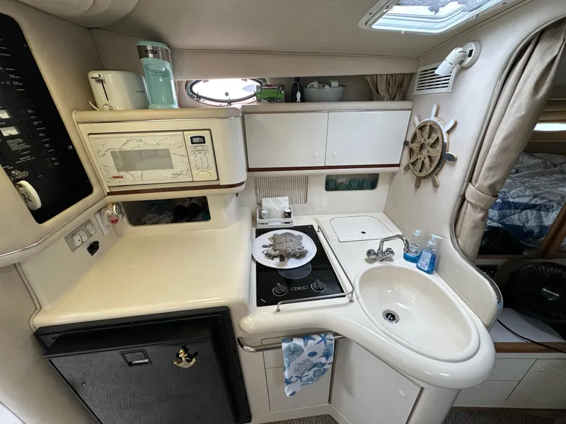 Slide: The Image of Interior of 1996 Sea Ray 330 Sundancer kitchen with sink, stove, and microwave. - 14