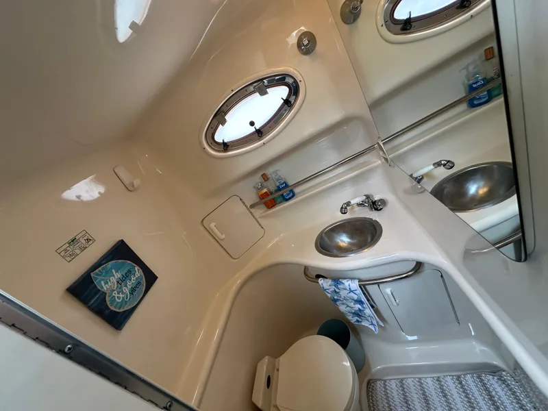 Slide: The Image of 1996 Sea Ray 330 Sundancer bathroom with sink, mirror, and porthole window. - 17