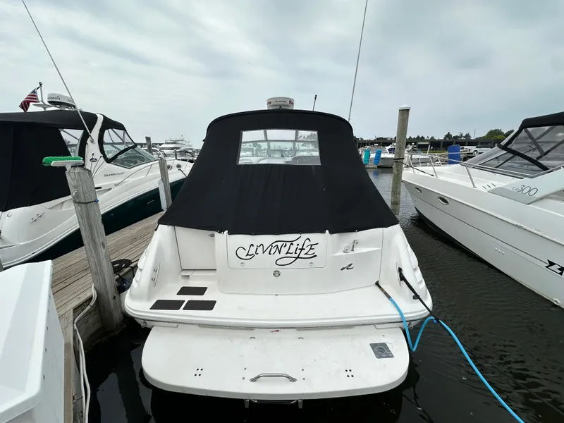 Slide: The Image of 1996 Sea Ray 330 Sundancer docked at marina, rear view with black cover. - 2
