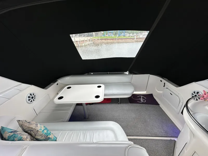 Slide: The Image of Interior of a 1996 Sea Ray 330 Sundancer with white seating and table. - 6