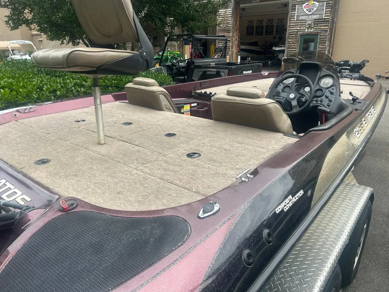 Slide: The Image of 2000 Stratos 21 SS Extreme boat with seating and steering console, parked outdoors. - 6