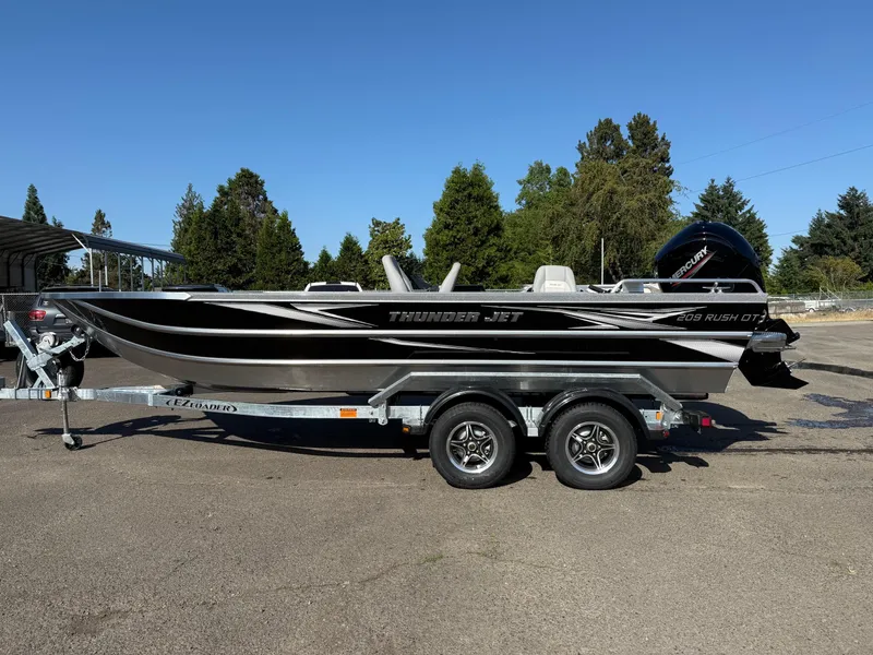Slide: The Image of 2025 Thunder Jet 209 Rush OT boat on trailer, parked outdoors. - 1