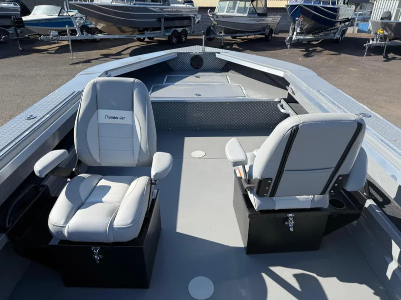 Slide: The Image of 2025 Thunder Jet 209 Rush OT boat interior with two seats, docked among other boats. - 15