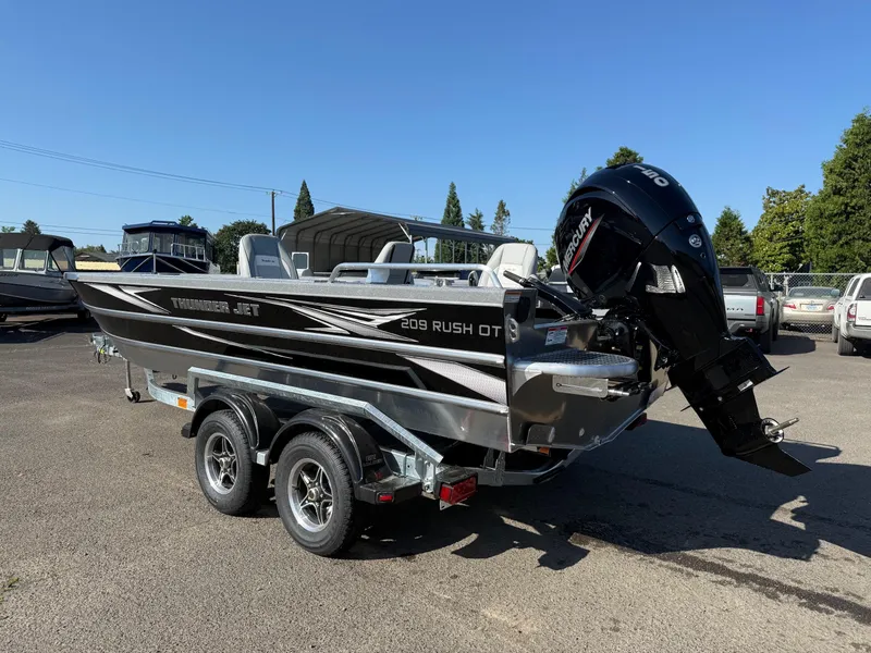 Slide: The Image of 2025 Thunder Jet 209 Rush OT boat on trailer, parked outdoors. - 2