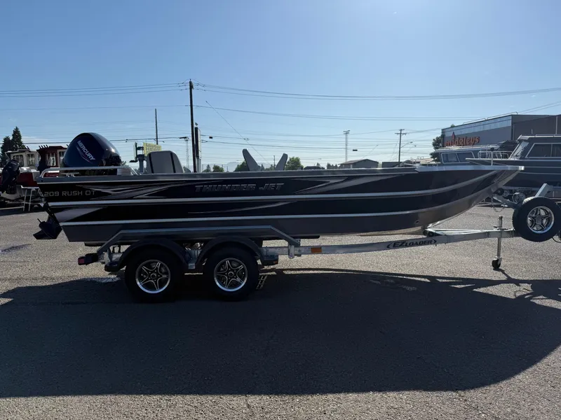 Slide: The Image of 2025 Thunder Jet 209 Rush OT boat on trailer, parked outdoors. - 4